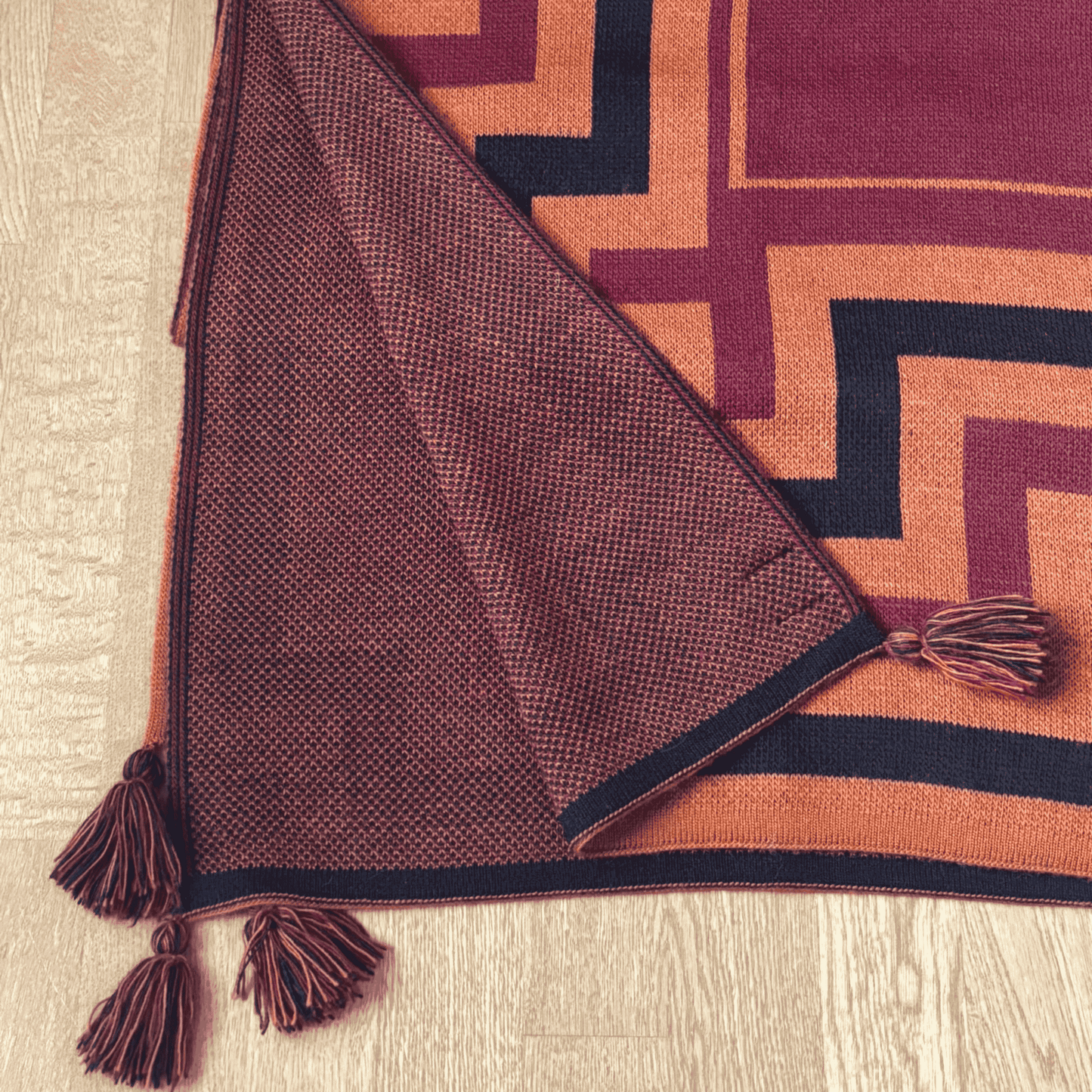 textured shawl with tassels on a geometric-patterned rug