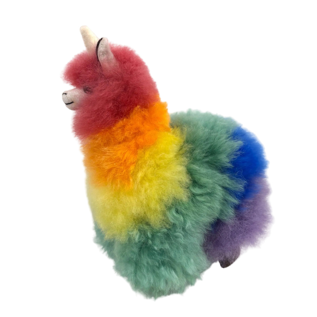 Colorful plush toy resembling a alpaca with a unicorn horn on a beige background