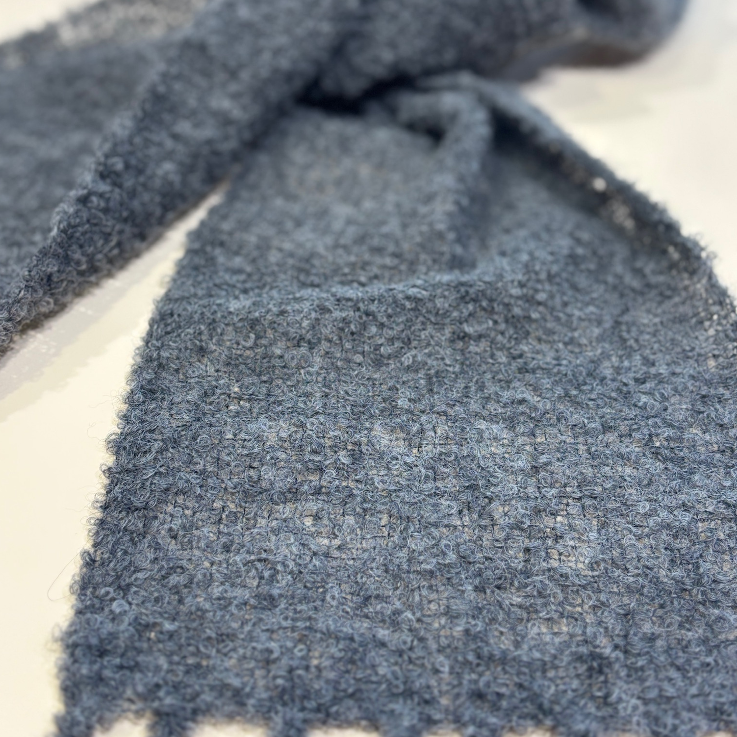 Close-up of a textured charcoal fabric on a light background