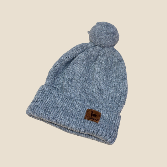 Gray knit beanie with a brand logo on a beige background
