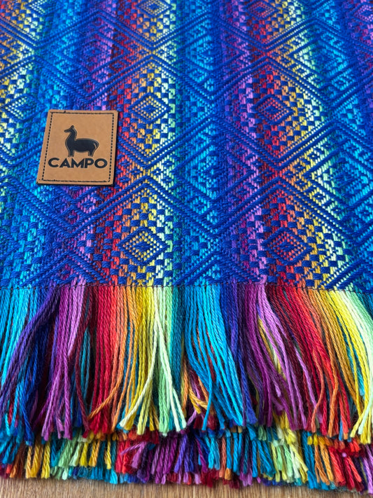 Closed up woven blanket with a brand logo on a wooden surface