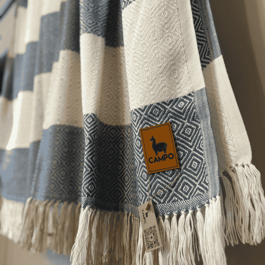 Textile with geometric patterns and a 'Campo' label, featuring fringes.