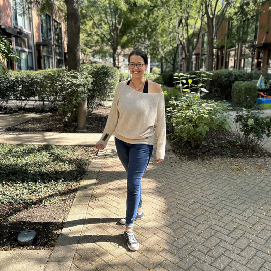 Woman walking on a sidewalk in an urban park setting