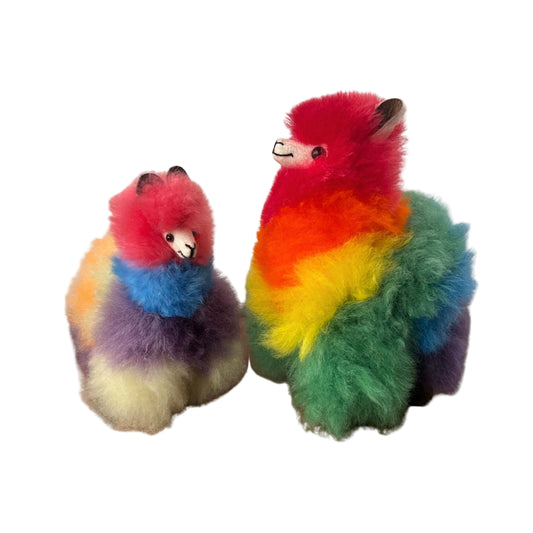 Two colorful plush toys resembling alpaca on a beige background