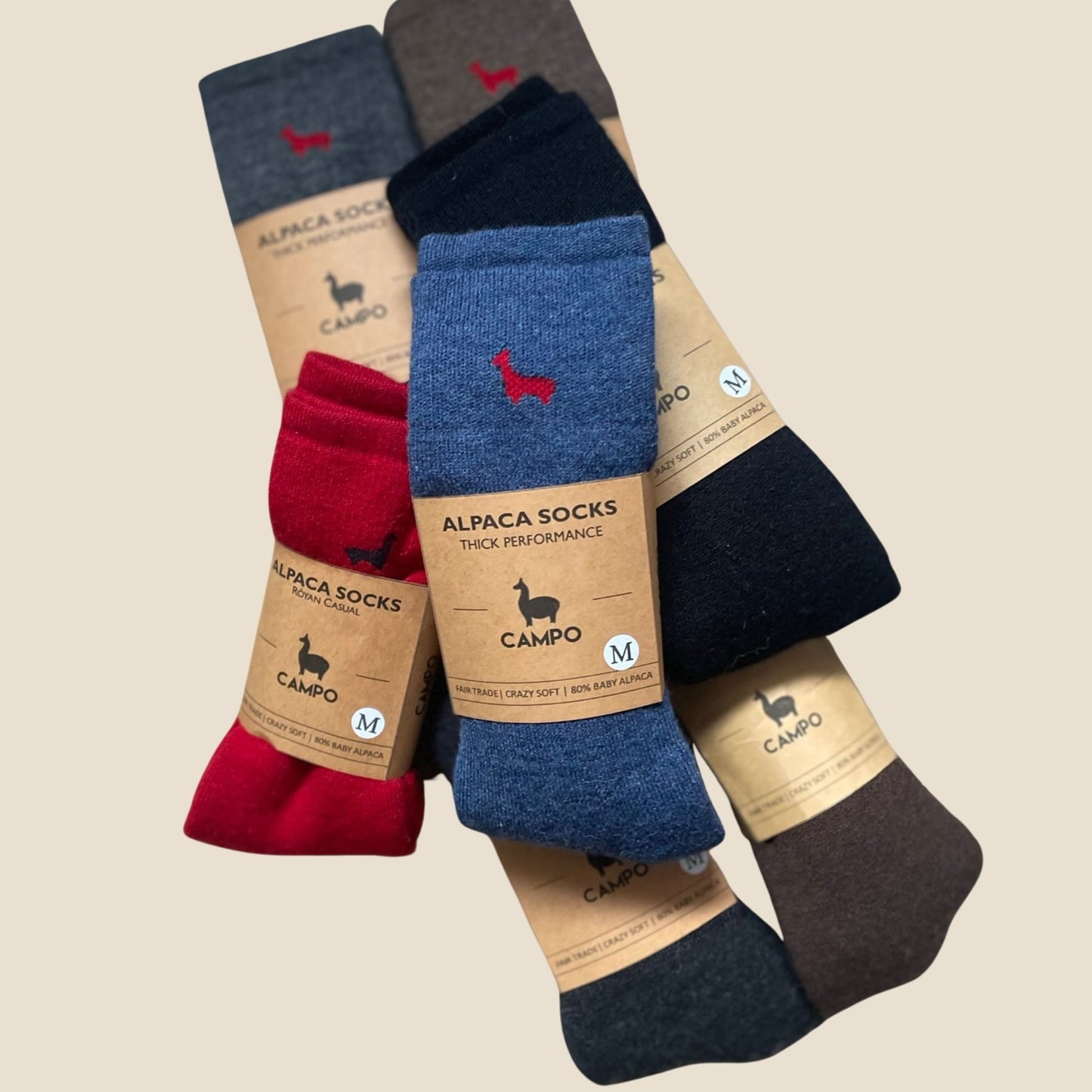 Set of alpaca socks with visible branding on a beige background
