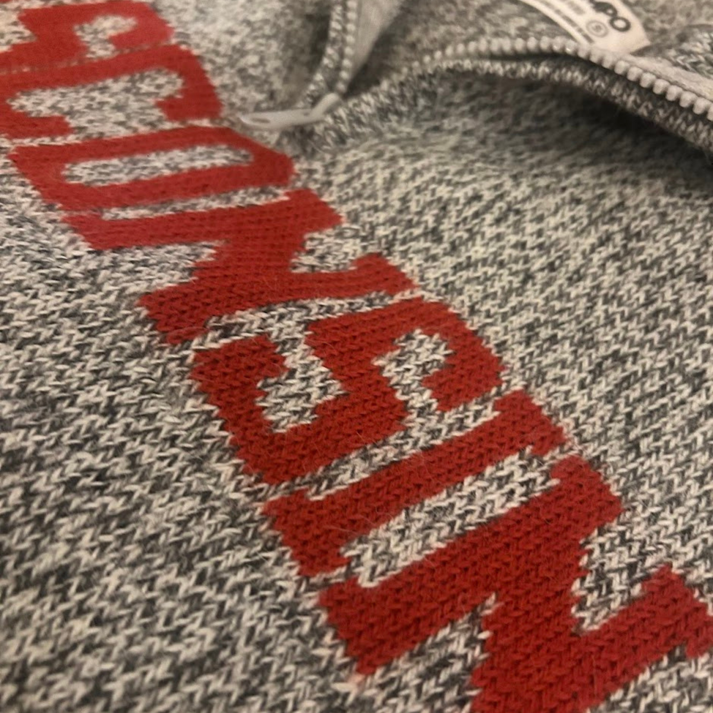 Textured fabric with red lettering on a gray background