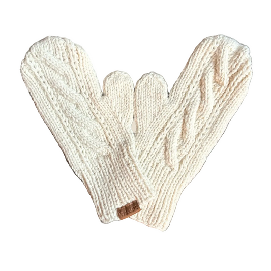 Pair of beige knitted mittens on a wooden surface