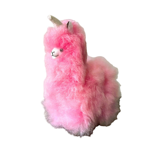 Pink plush toy resembling a alpaca on a beige background