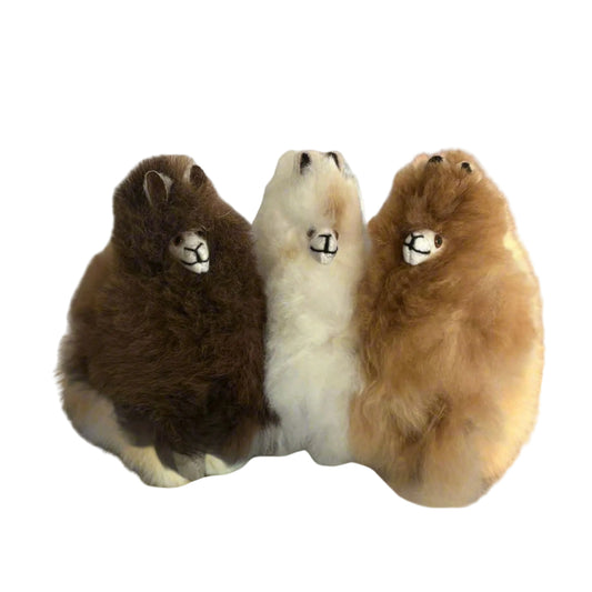 Three plush toys alpaca on a beige background