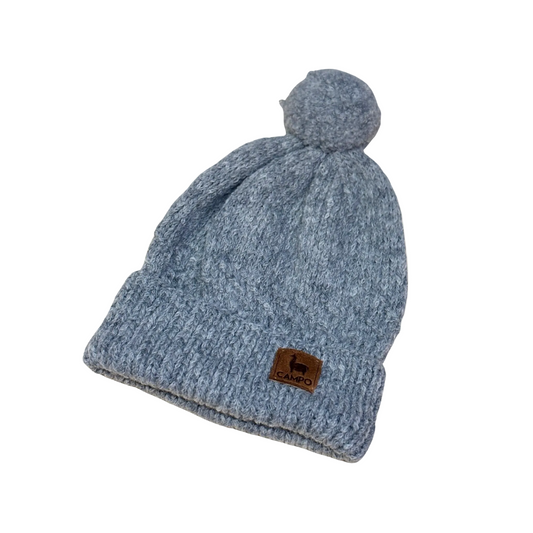 Gray knit beanie with a brand logo on a beige background