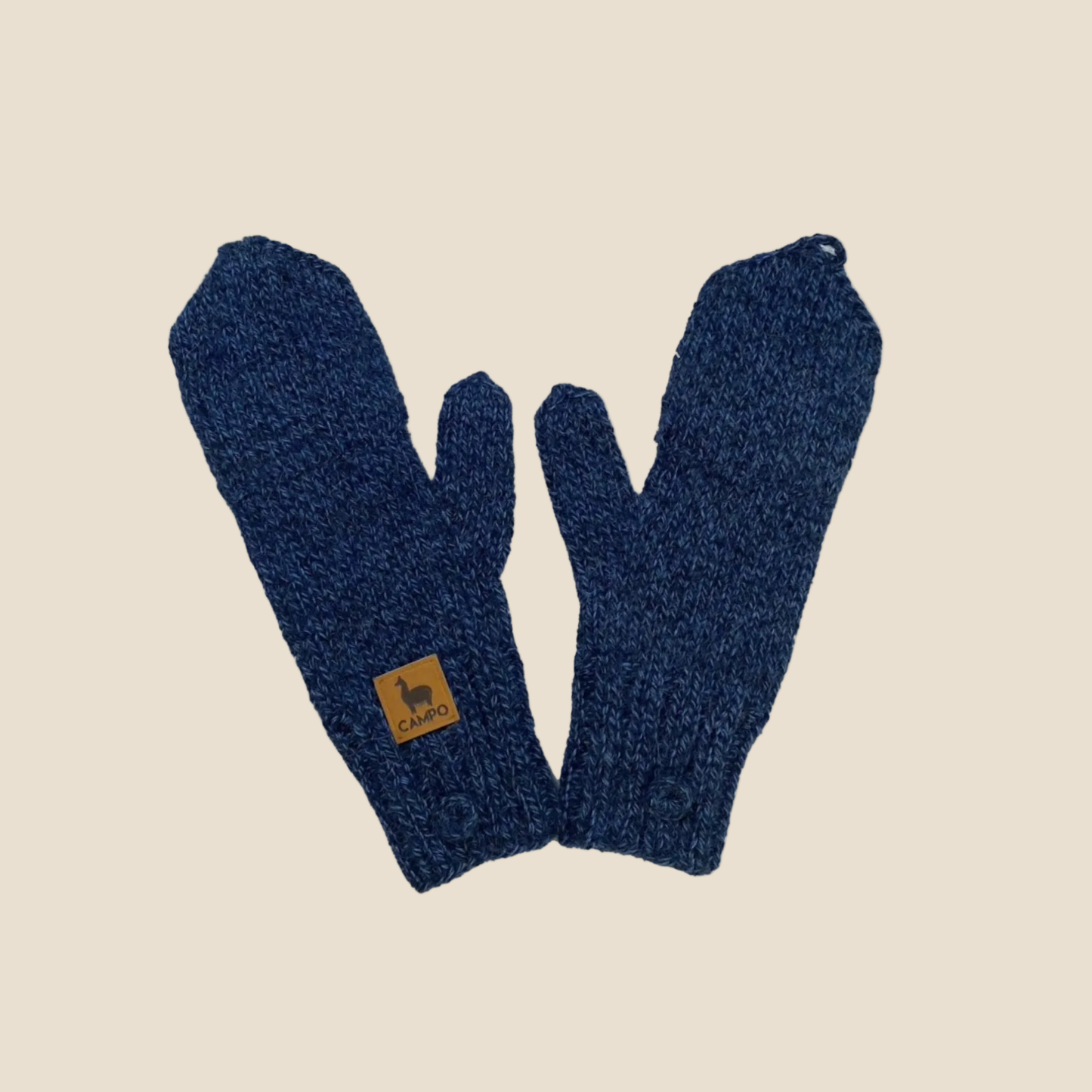 Pair of blue knitted gloves with a brand label on a beige background