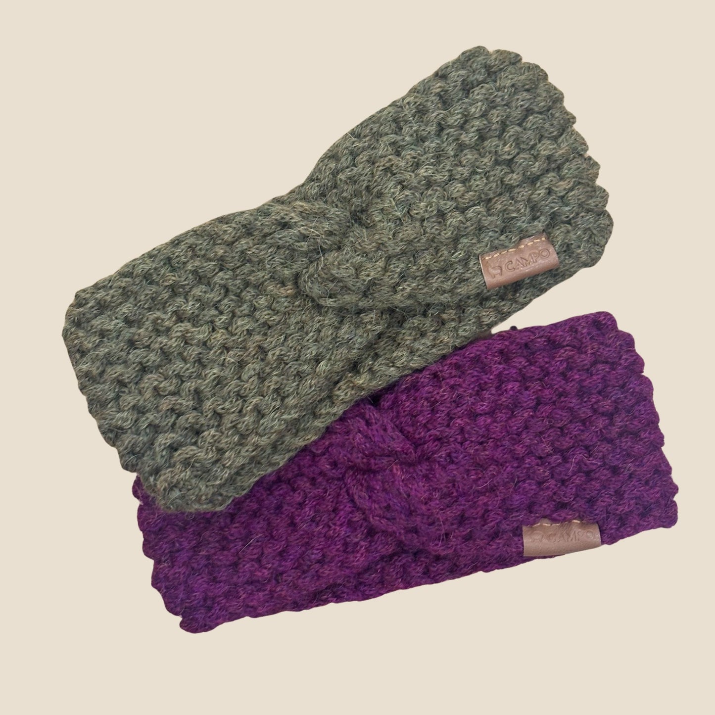 Two knitted headbands, one olive green and one purple, on a beige background.