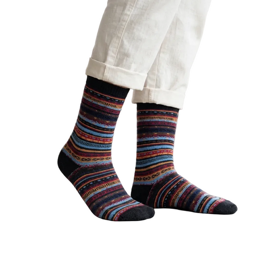 Multicolored striped socks worn with white pants on a beige background
