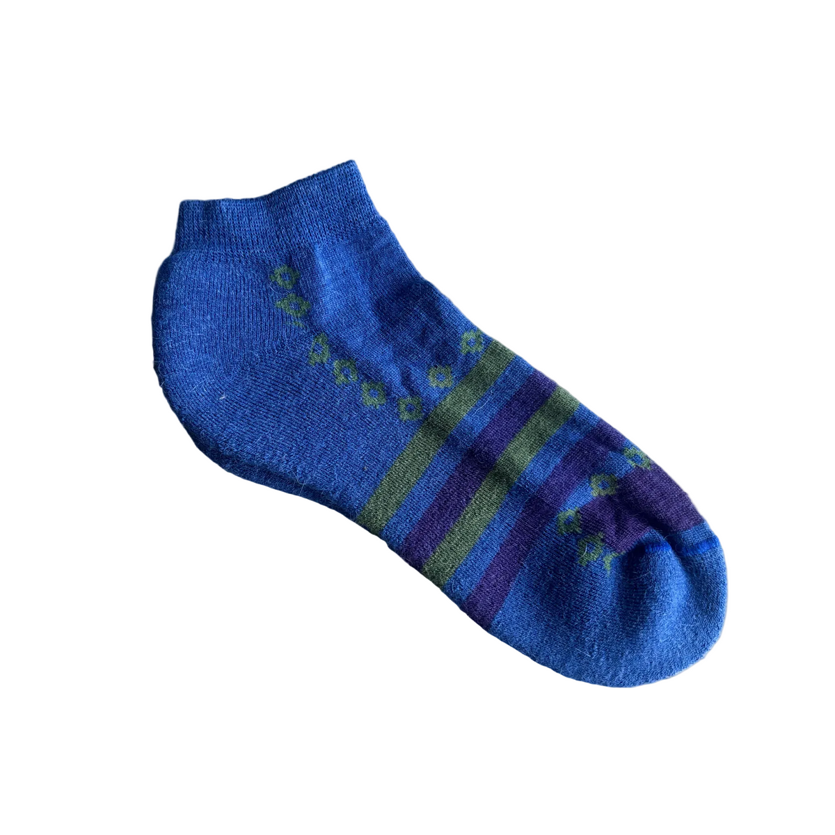 Blue sock with green and purple stripes on a beige background