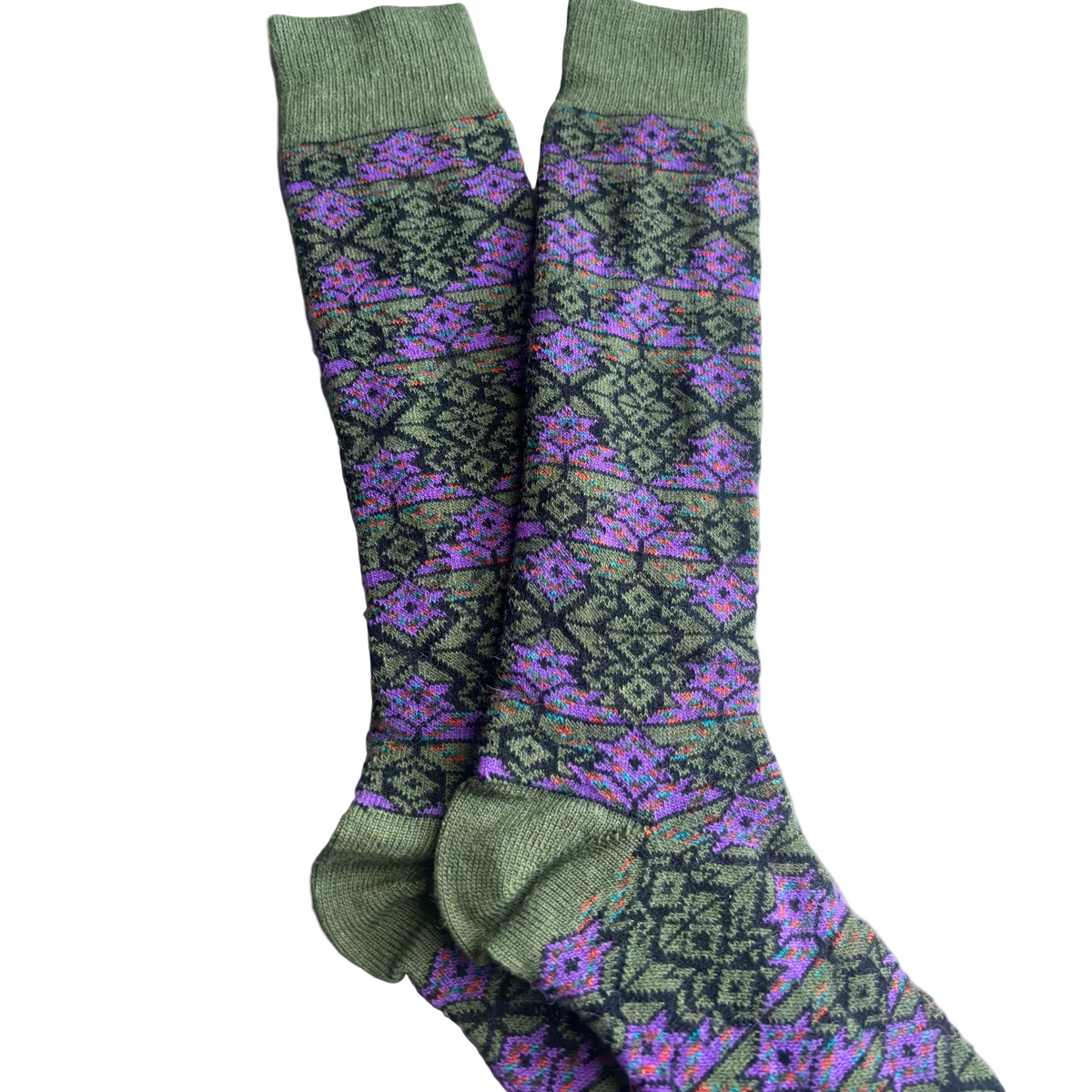 Green and purple patterned socks on a wooden floor