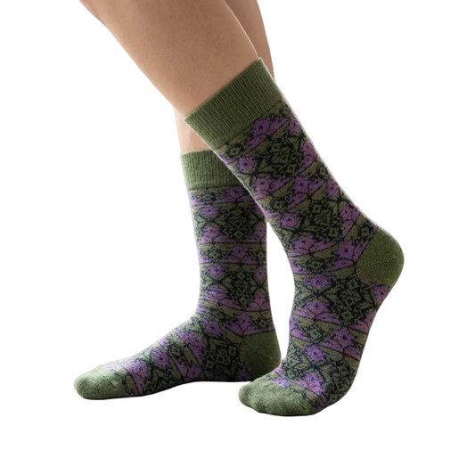 Green and purple patterned socks worn by a person indoors.