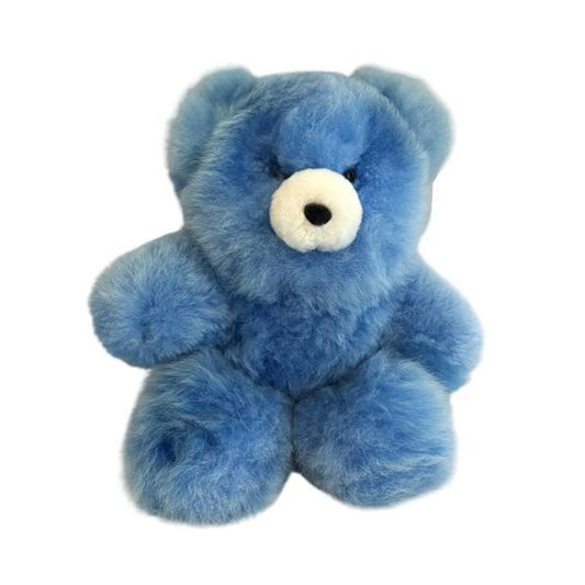 Blue teddy bear with a white nose on a beige background