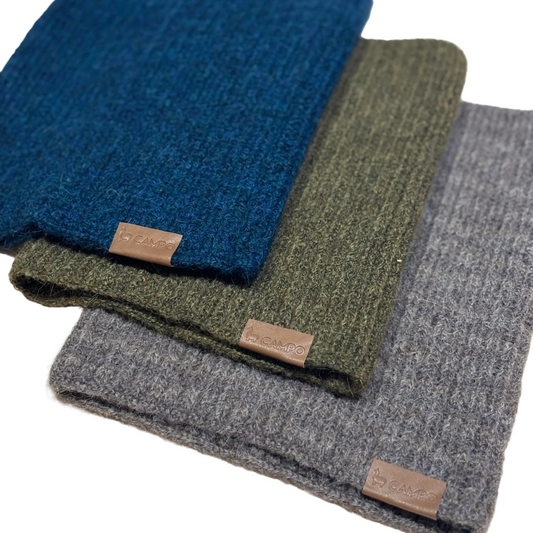 Three folded scarves in blue, green, and gray with visible brand labels on a light background.