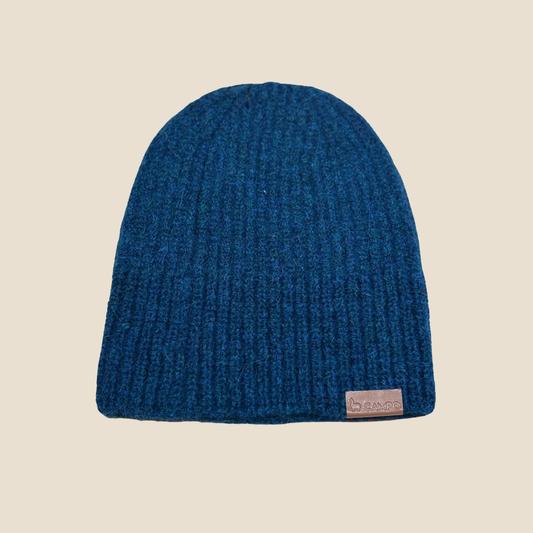 Blue knit beanie with a brand label on a beige background