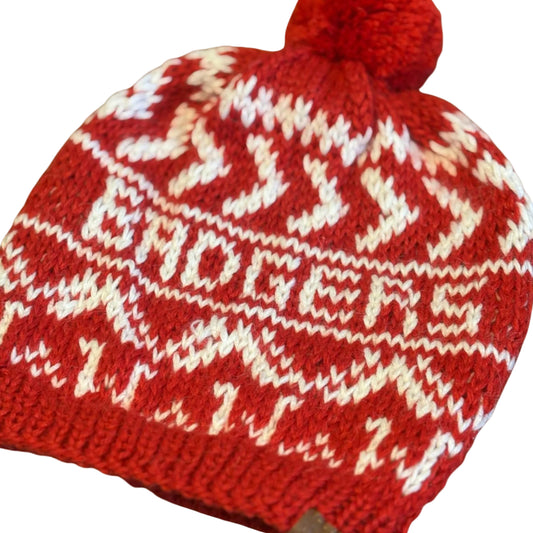 Red knit beanie with white pattern on a beige background