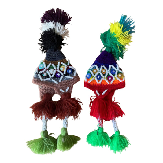 Two colorful handcrafted toys with intricate patterns on a beige background