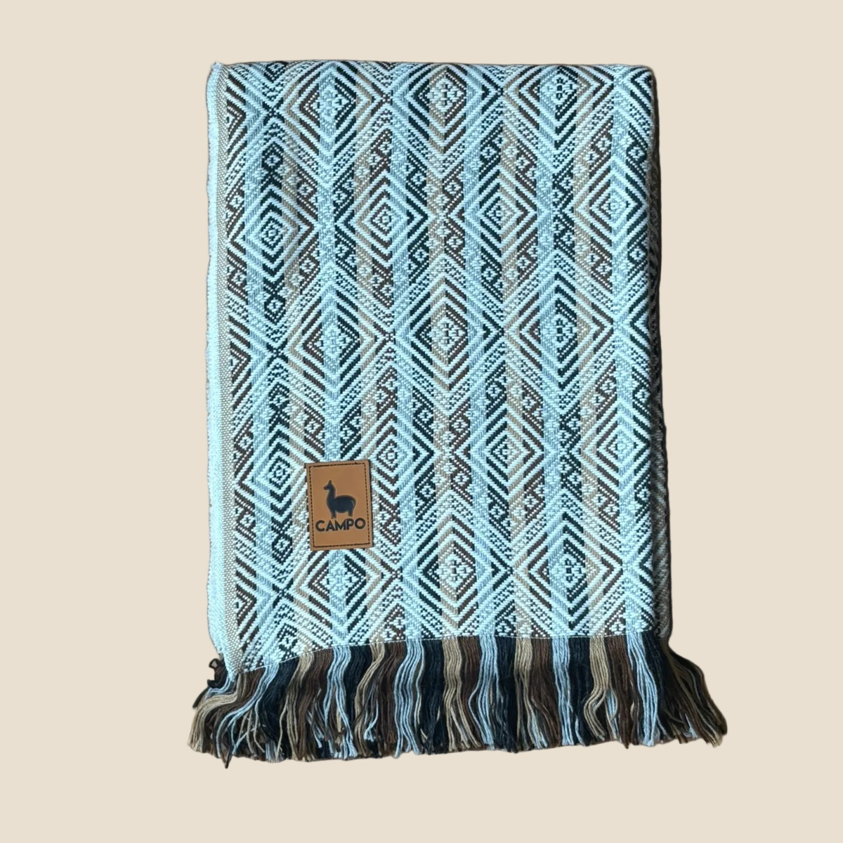 Blue and brown patterned blanket with fringes on a beige background