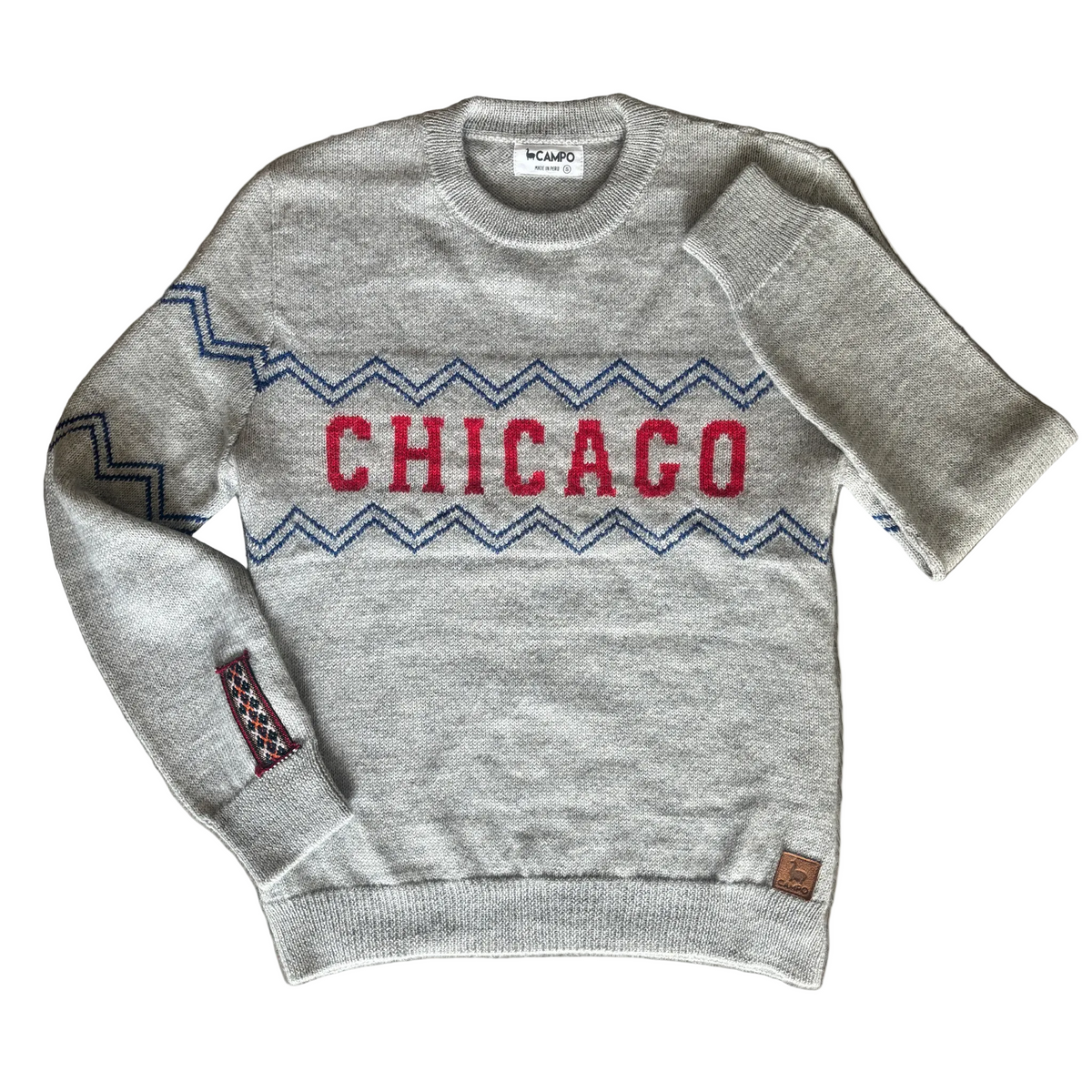 Gray sweater with 'Chicago' design on a wooden surface