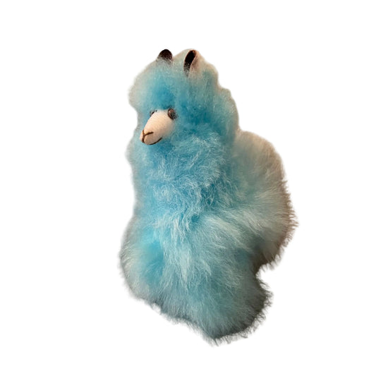 Blue plush alpaca toy on a beige background