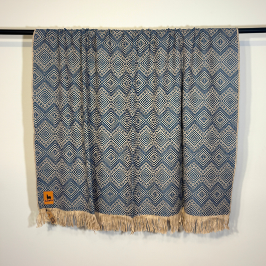 Blue patterned fabric with fringes on a white background