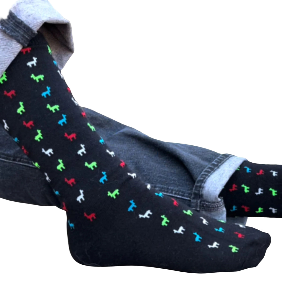 Black socks with colorful alpaca pattern worn with blue jeans on a beige background