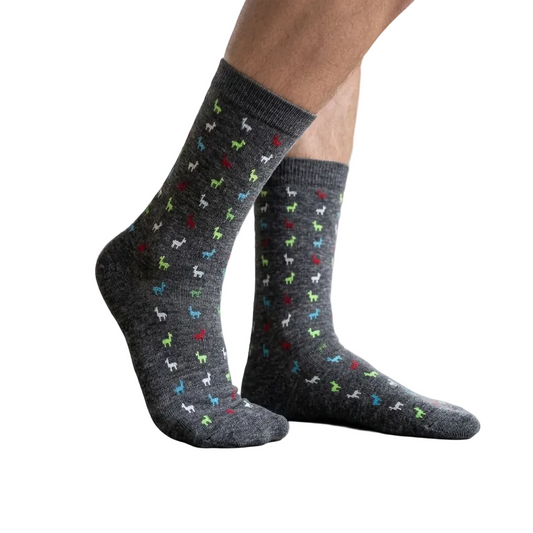 Gray socks with colorful dog patterns worn indoors on a light wooden floor.