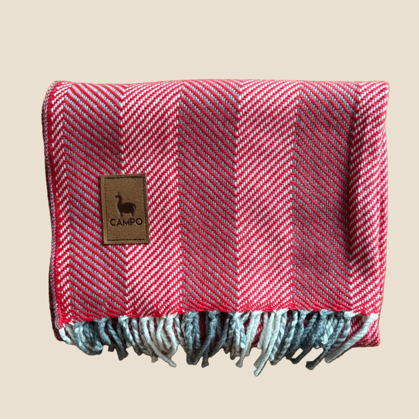 Red herringbone patterned blanket with a 'Campo' label on a beige background