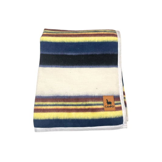 Striped blanket with a brand logo on a beige background