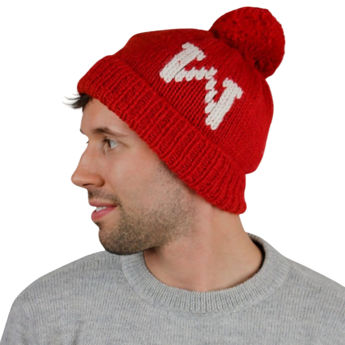 Man wearing a red knit beanie with white text on a beige background