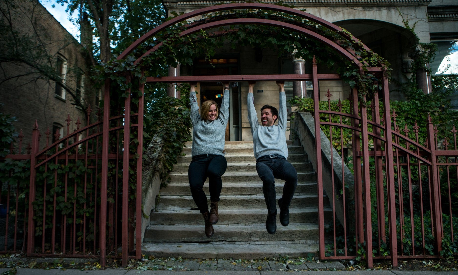 People hanging on gate outside and smiling wearing salt and pepper alpaca crew neck sweater
