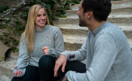 People smiling and talking wearing salt and pepper alpaca crew neck sweater