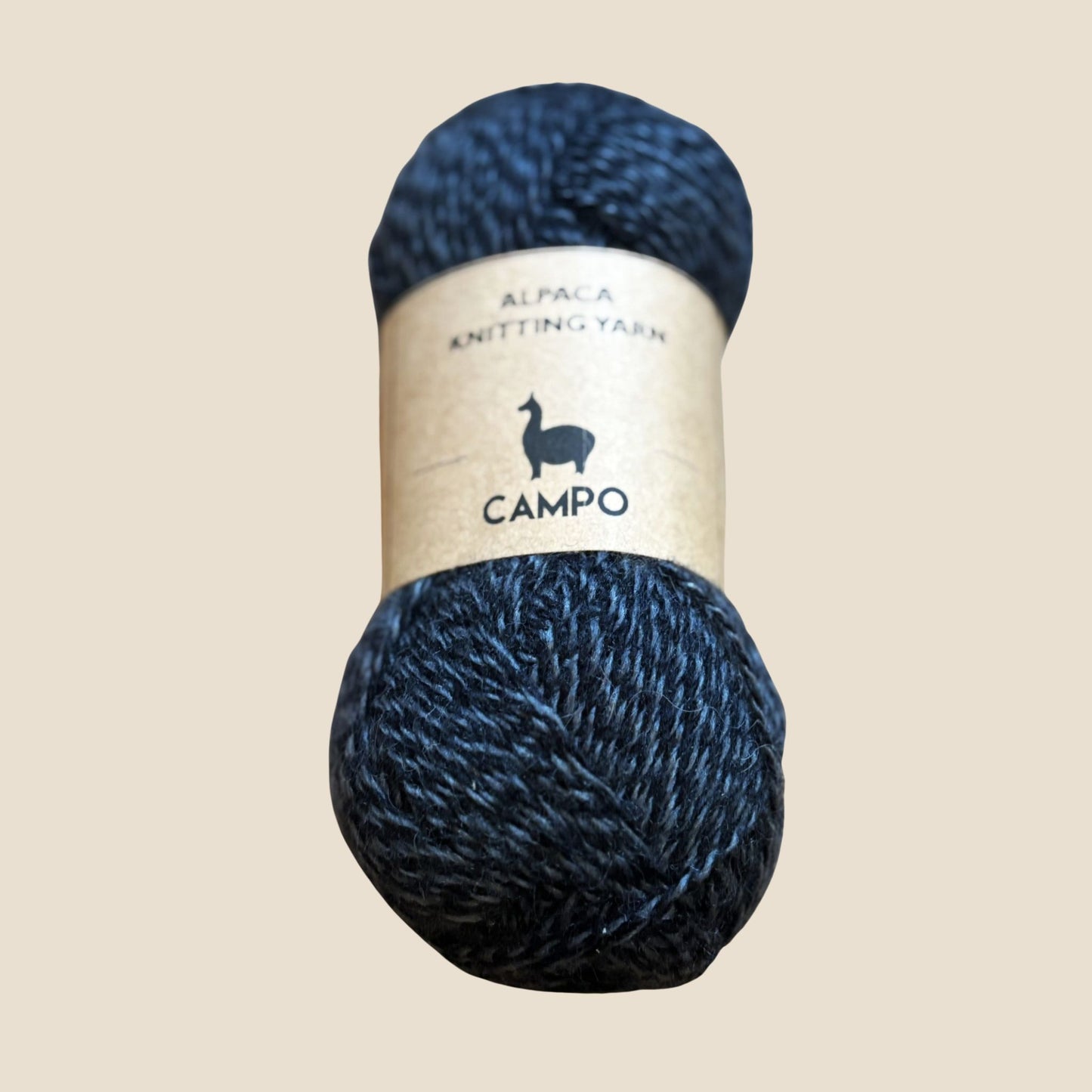 Melange skein of alpaca knitting yarn with 'Campo' label on a beige background