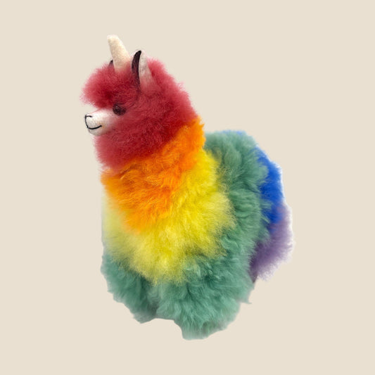 Colorful plush toy with rainbow fur on a beige background