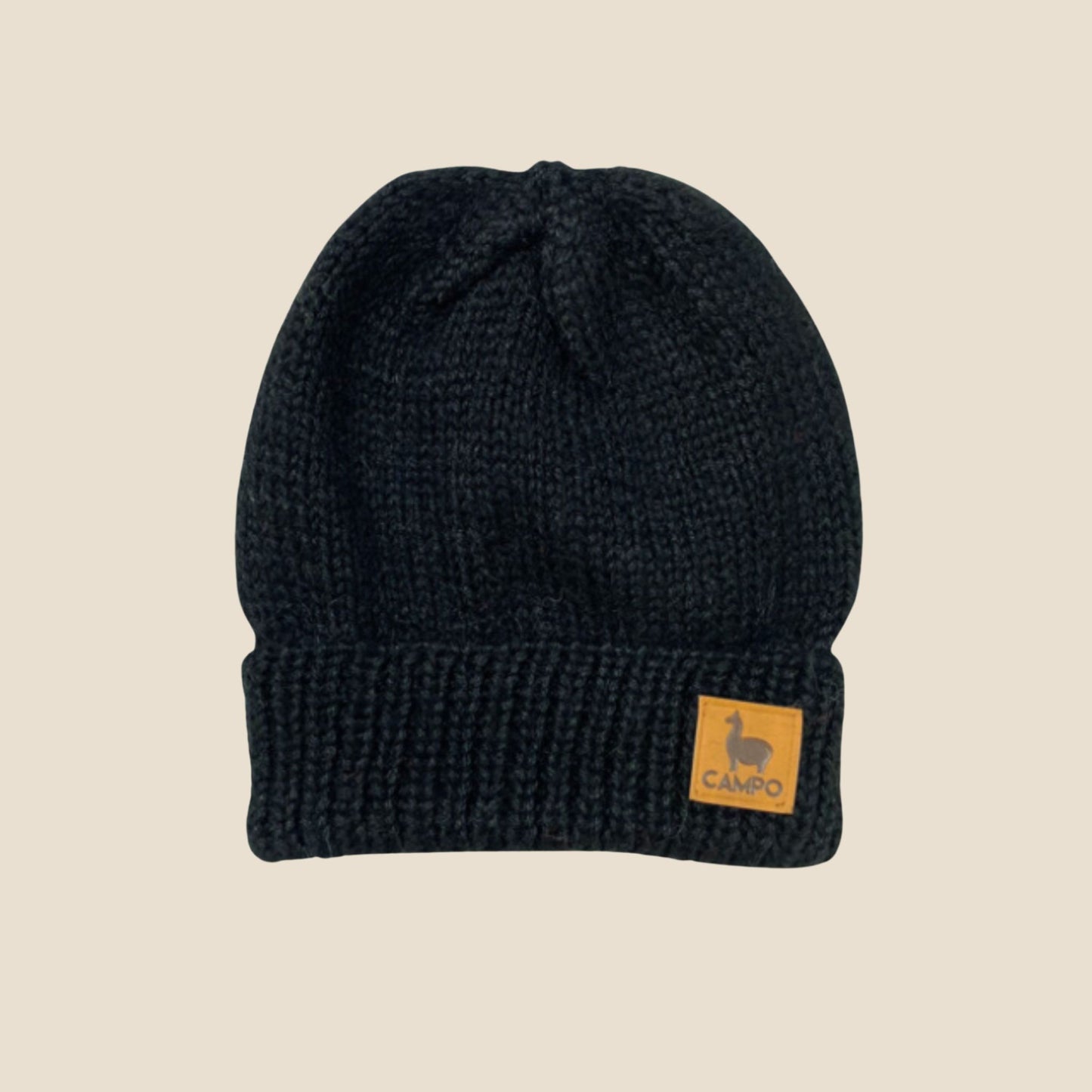 Black knit beanie with a Campo logo on a beige background