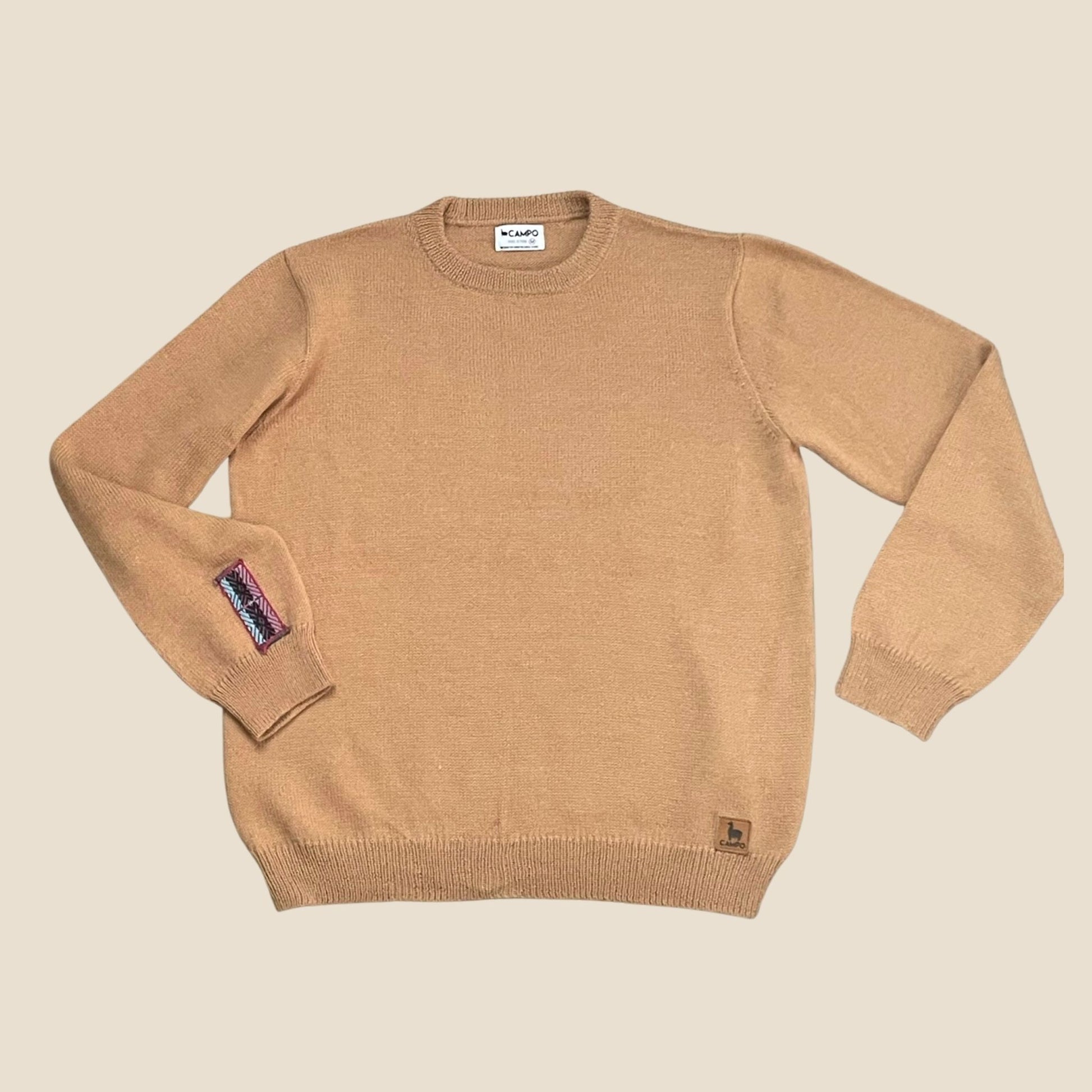 Camel sweater with brand labels on a beige background