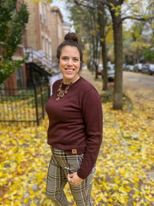 Woman standing on a street with autumn leaves and buildings in the background