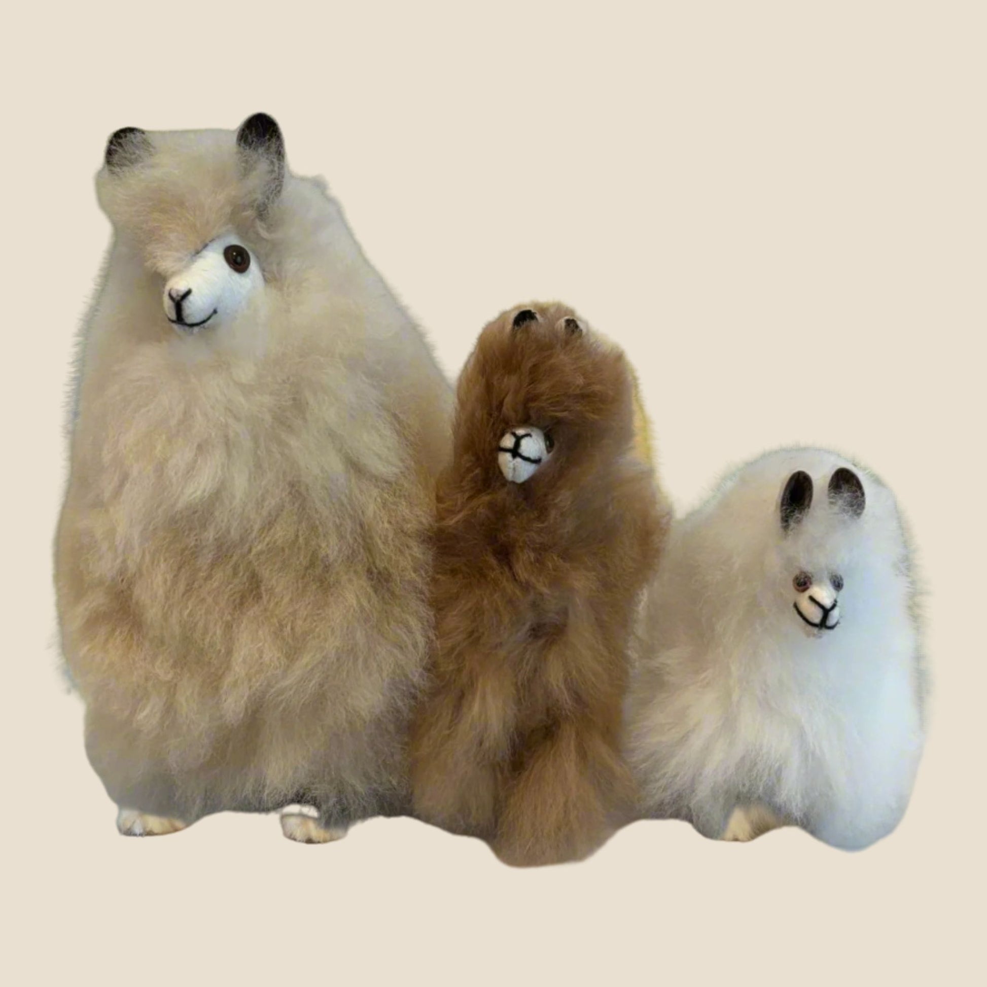 Three plush toys alpaca on a beige background