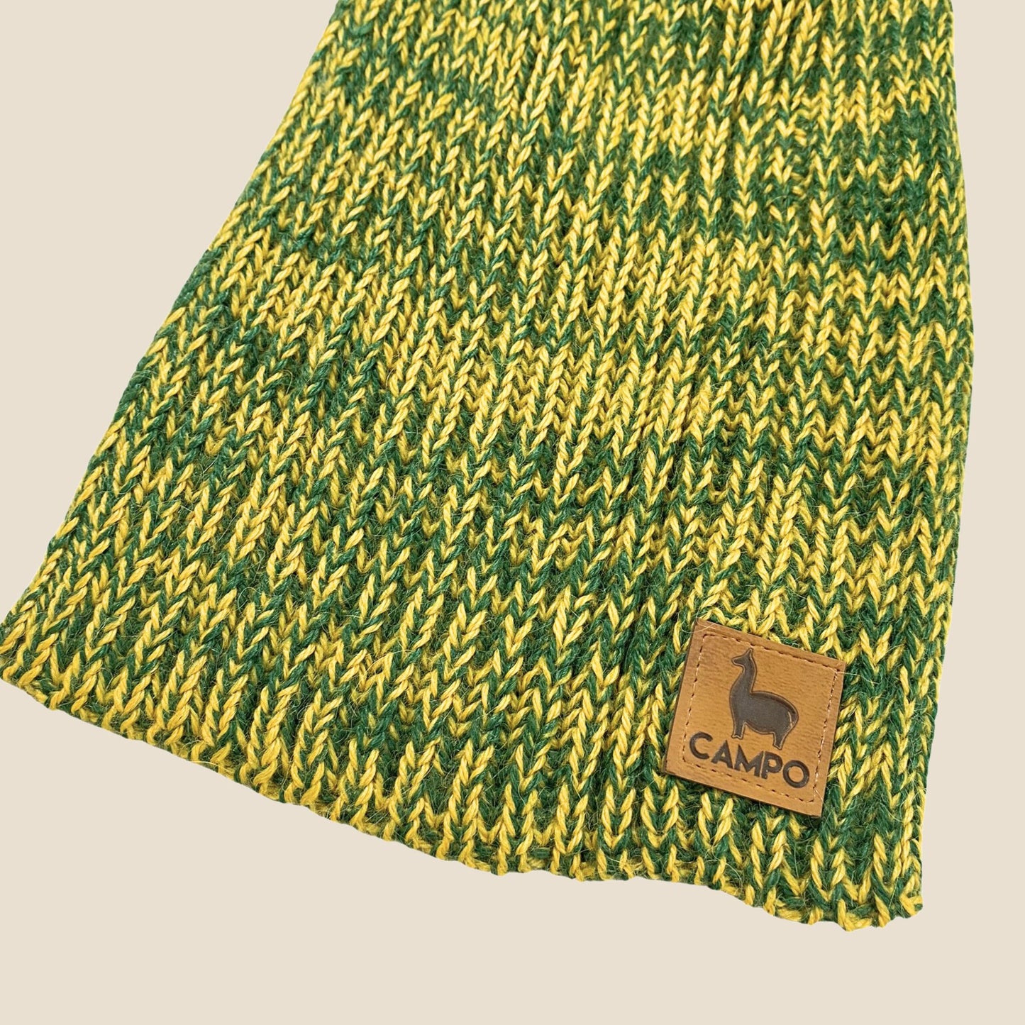 Green and yellow knitted fabric with a 'Campo' brand label on a beige background