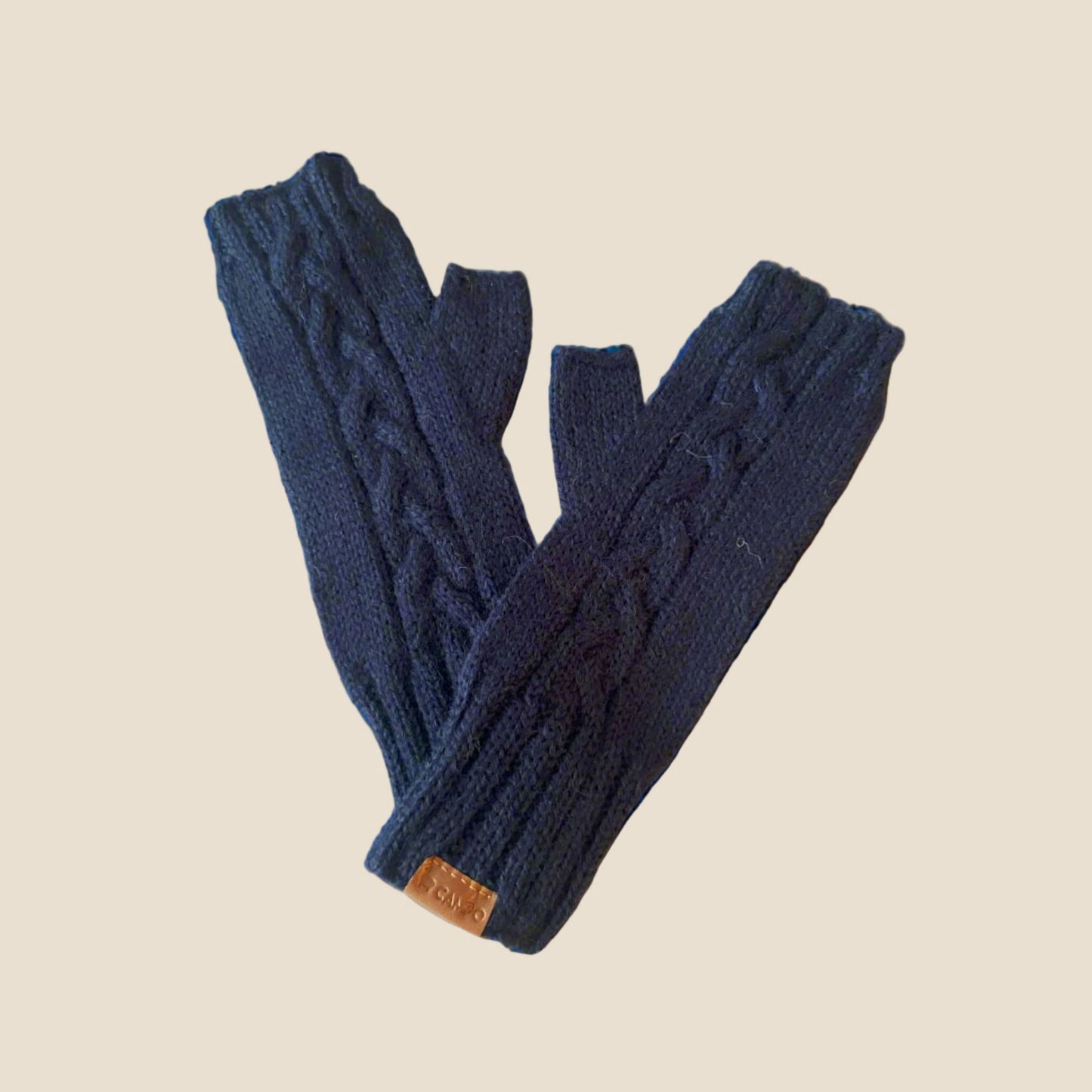 Pair of blue knitted fingerless gloves on a beige background