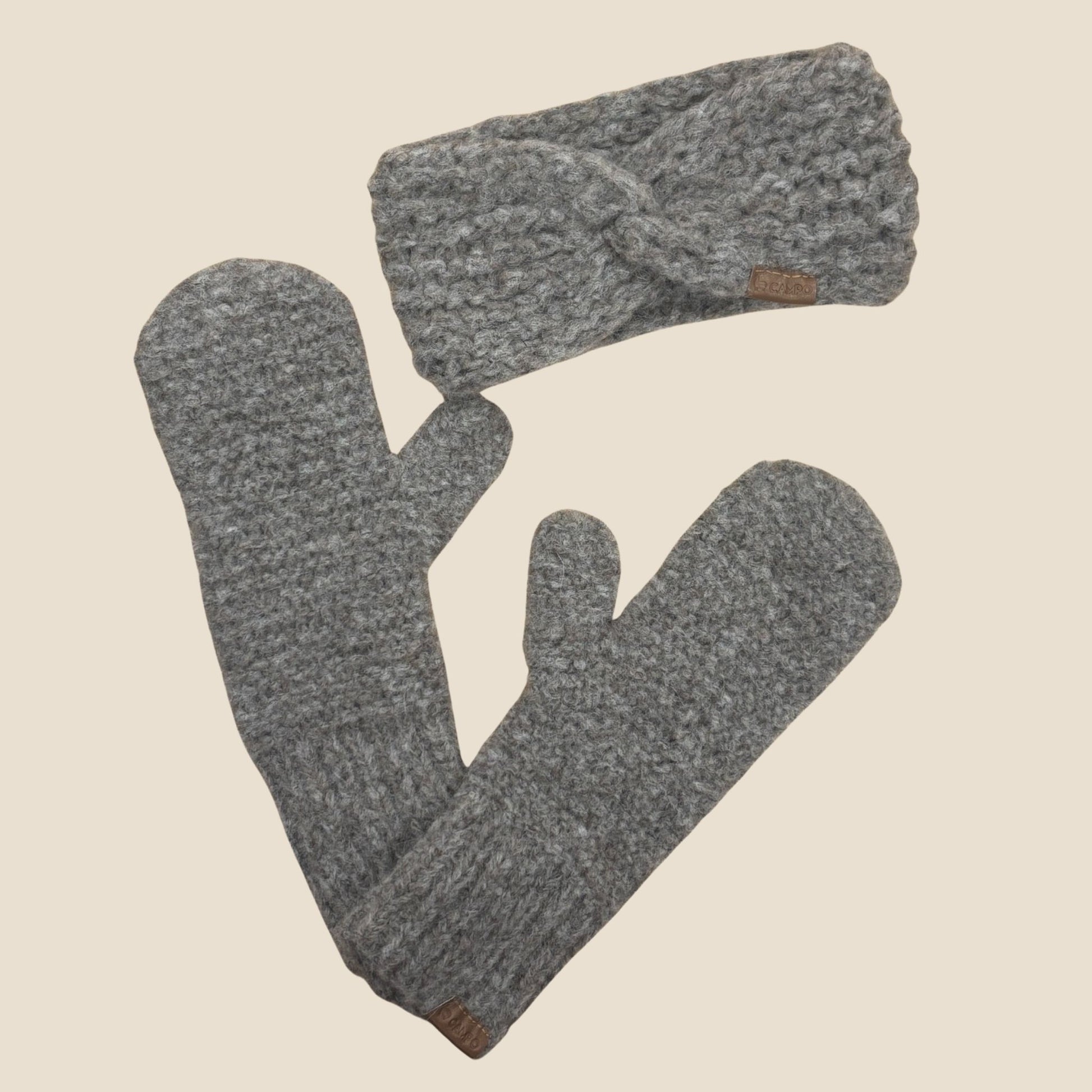 Oatmeal knitted headband and mittens set on a beige background