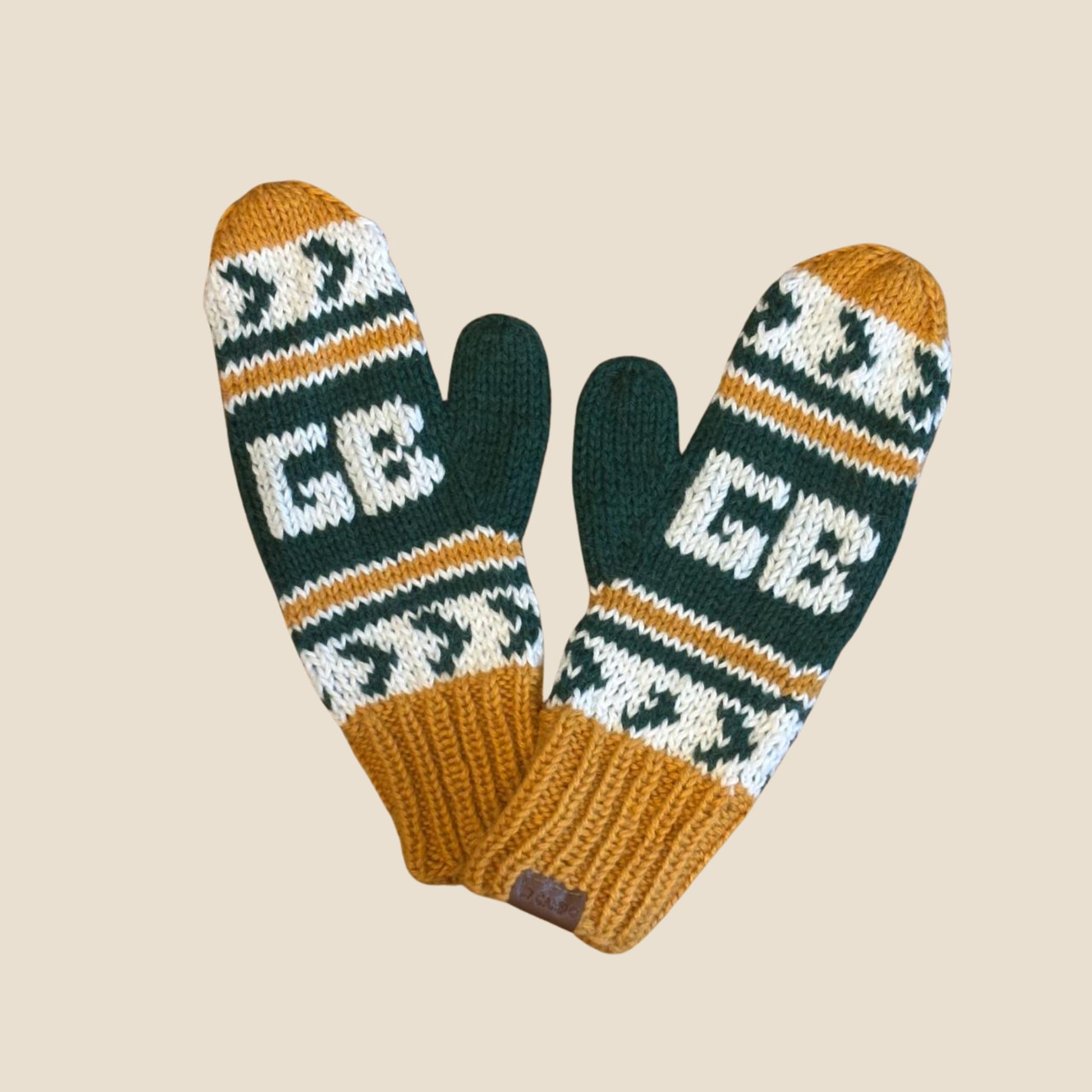 Pair of knitted mittens with a pattern and text on a beige background