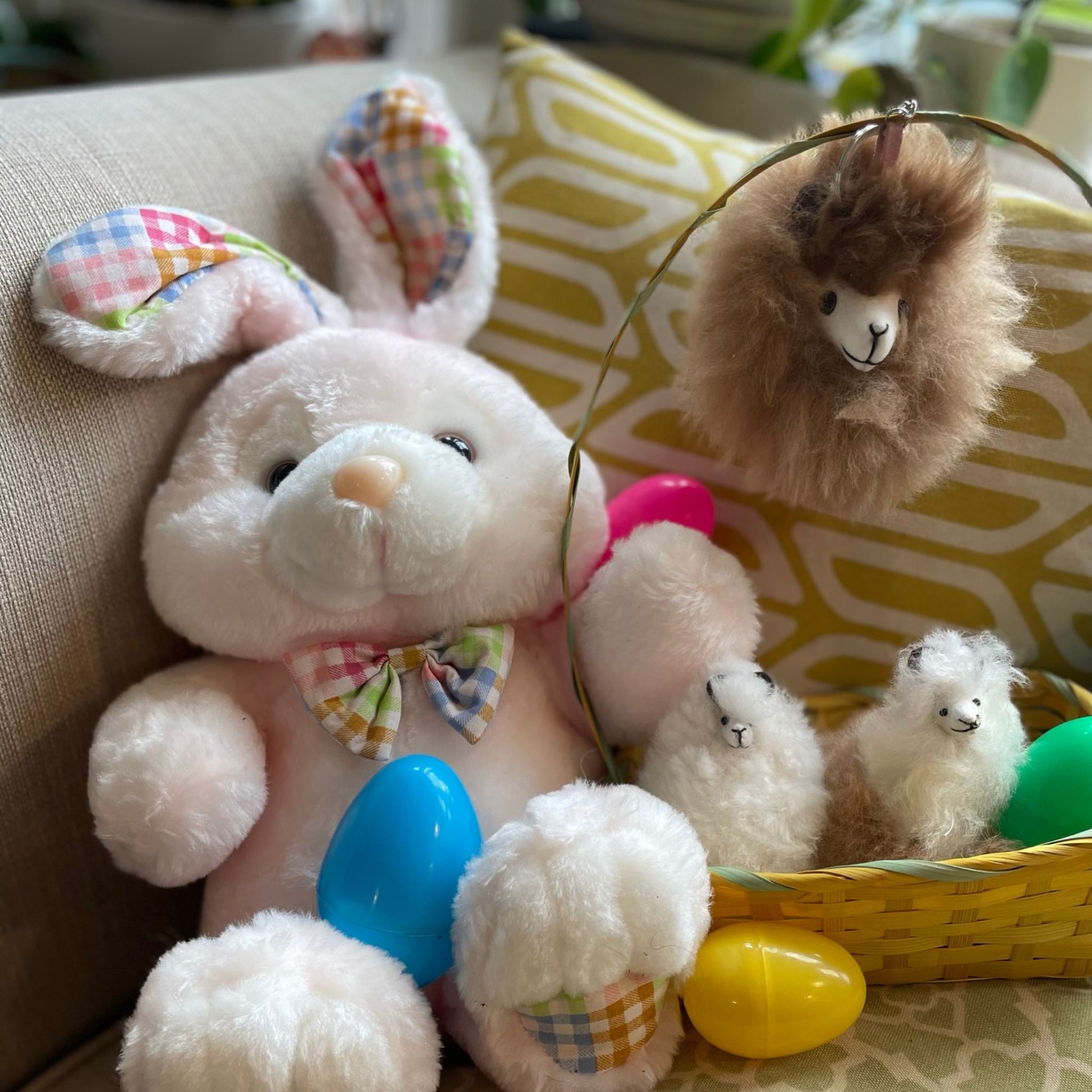 Plush bunny with baby bunnies and Easter eggs on a couch