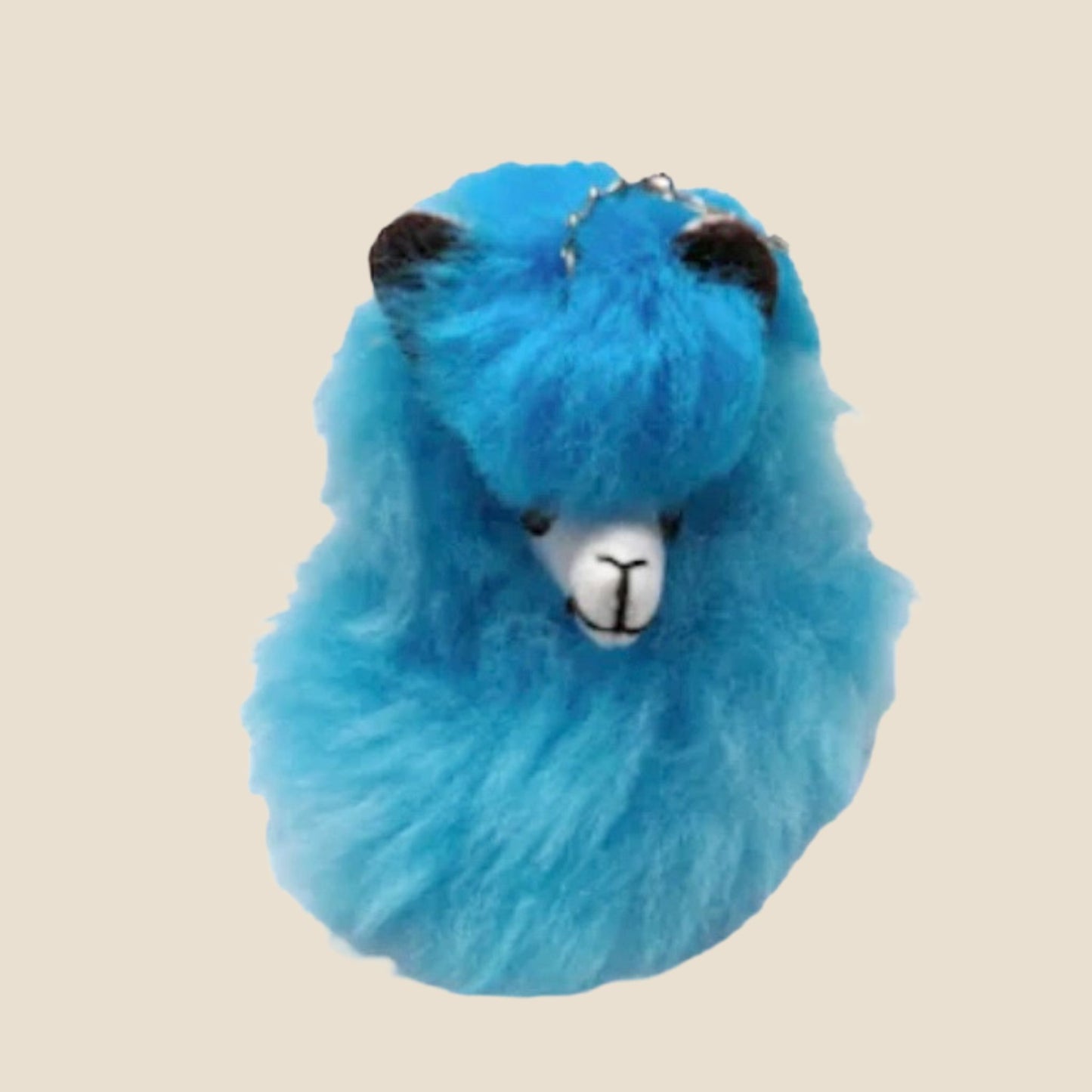 Light Blue plush alpaca toy on a beige background