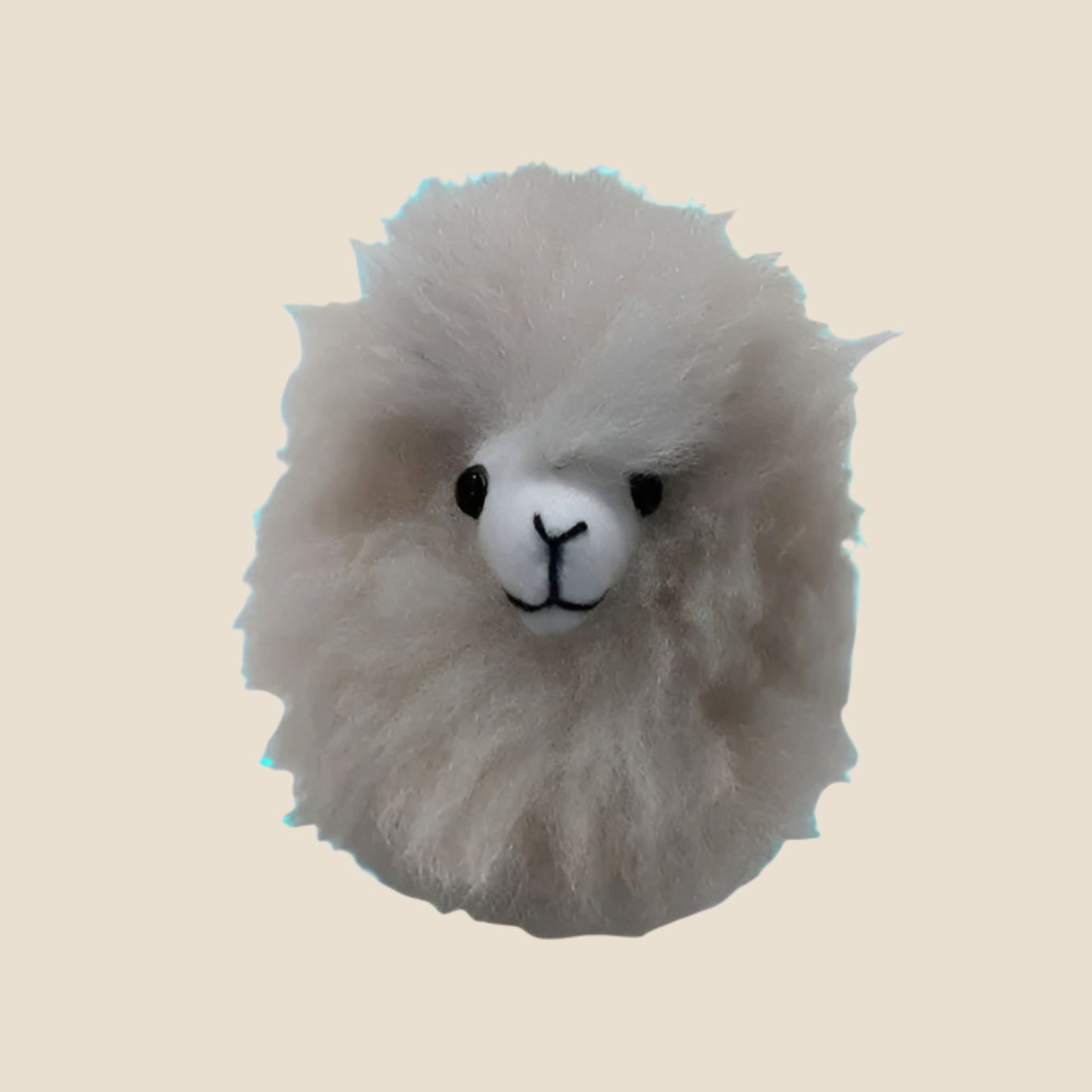 Plush toy resembling a alpaca head on a beige background