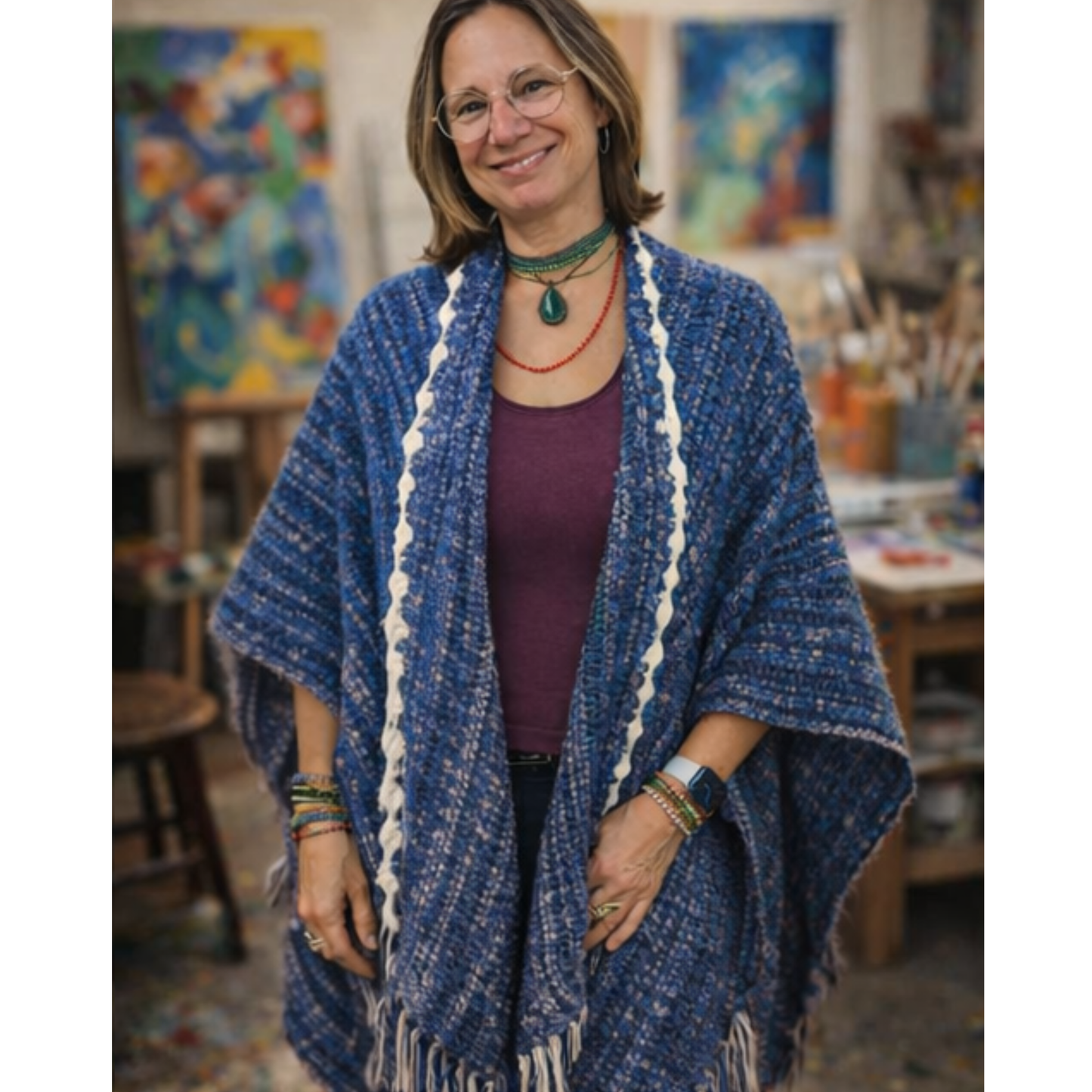Woman wearing a blue knitted shawl in an art studio setting
